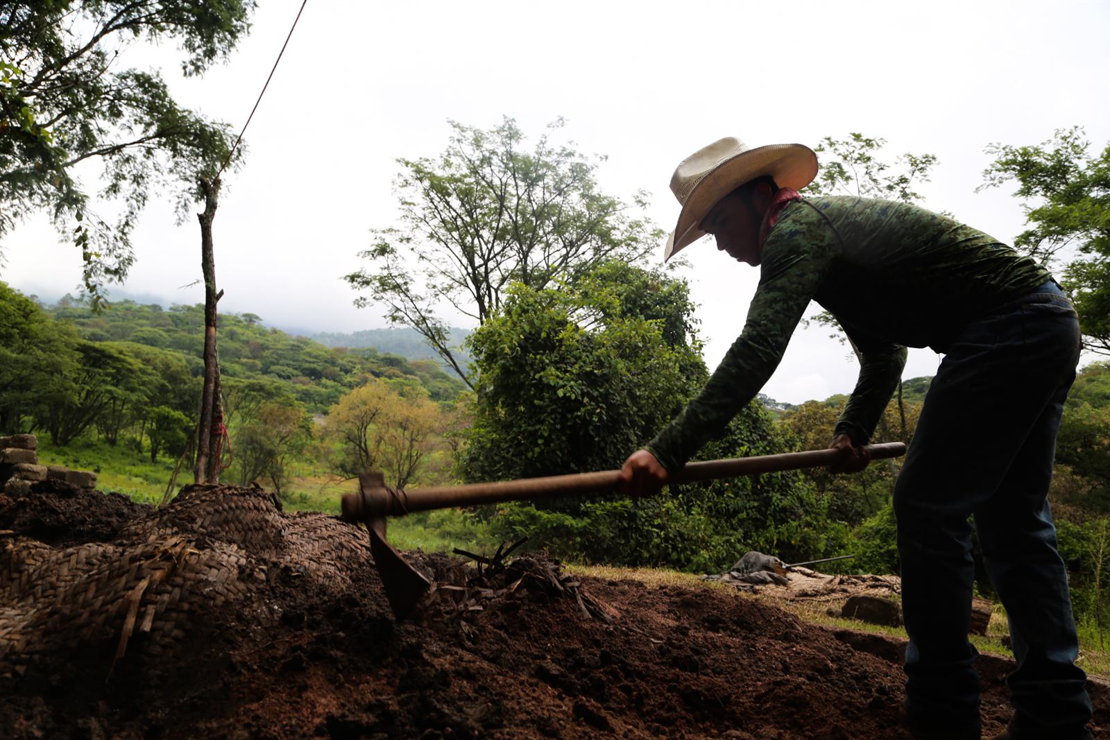 Mezcalero cerrando el horno de tierra con piedra volcánica